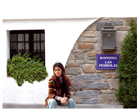 Mujer en fachada de casa rural de la Reserva de la Biosfera